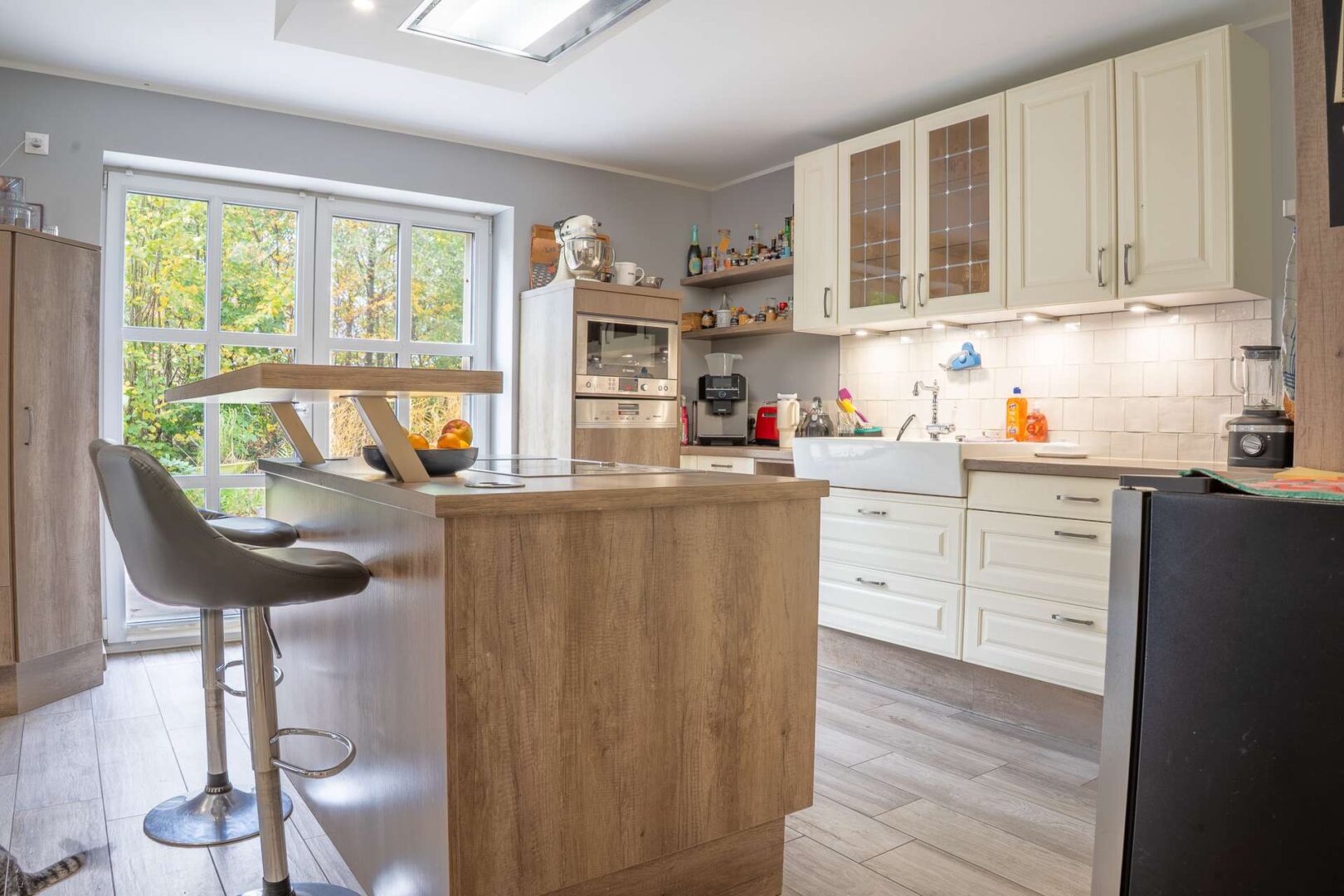 Helle Landhausküche mit Austritt zur Terrasse