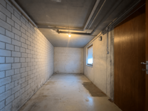 Leerer Kellerflur mit freigelegter Backsteinwand